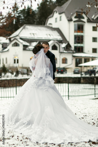 The brides embrace near frozen lake