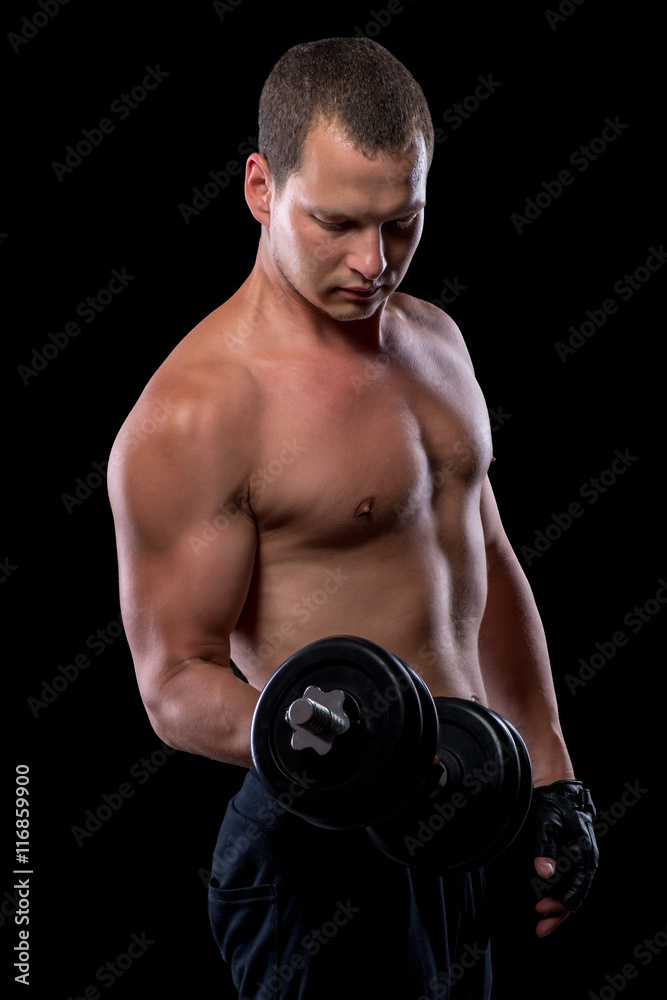 portrait of an athlete with dumbbells while training in a dark r