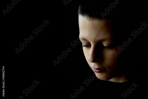 The Sad Boy With Tears in Their Eyes on a Black Background