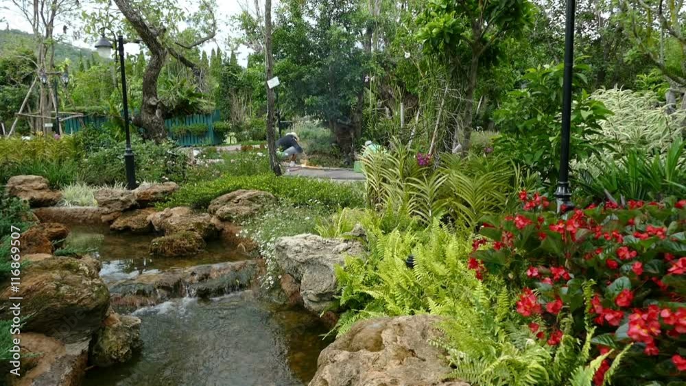 man made waterfall and canal in the garden with the worker is welding metal in background man made waterfall and canal in the garden with the worker is welding metal in background