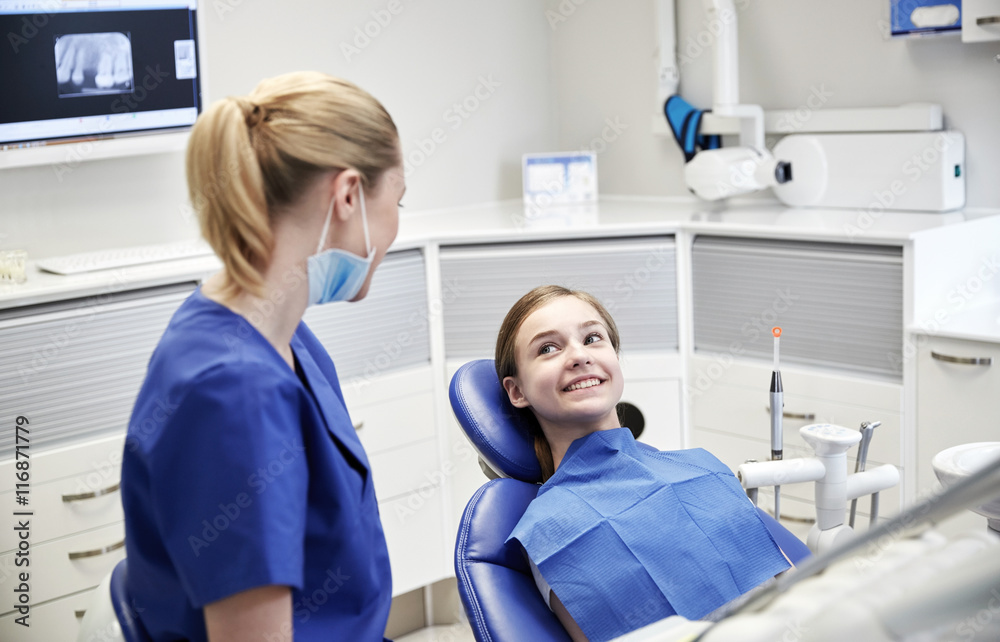happy female dentist with patient girl at clinic happy female dentist with patient girl at clinic