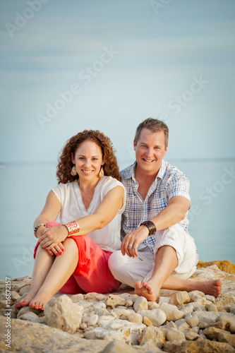Cute Couple Sitting on Rocks at the Beach