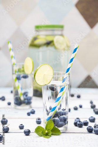 Glass of infused water with lime, blueberries and mint photo