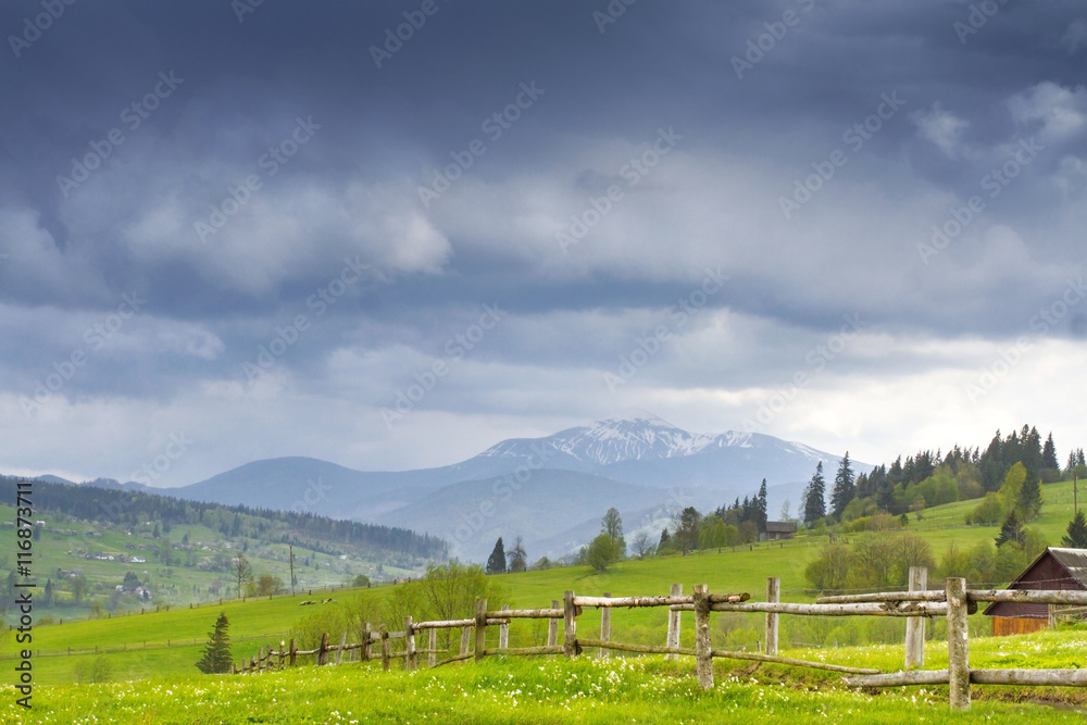 Carpathian mountain valley with road and fence