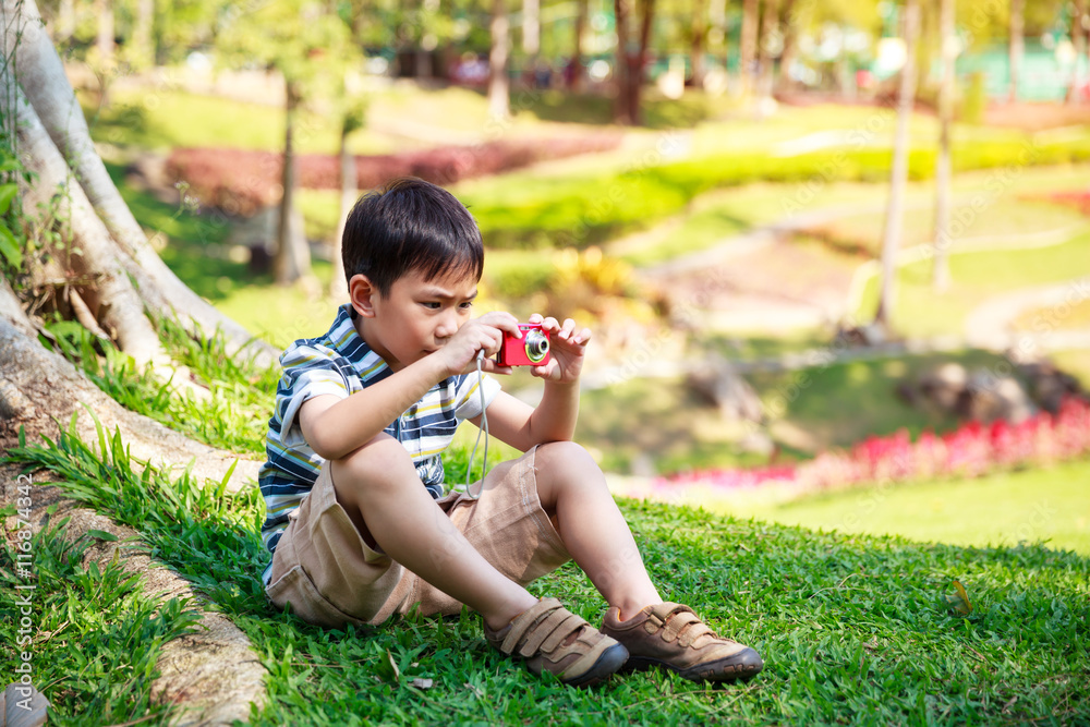 Asian boy with camera relaxing outdoors in the day time, travel on vacation. Asian boy with camera relaxing outdoors in the day time, travel on vacation.