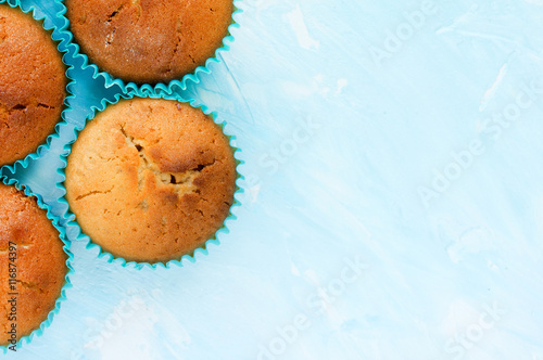 Muffins on blue background blank space for text top view