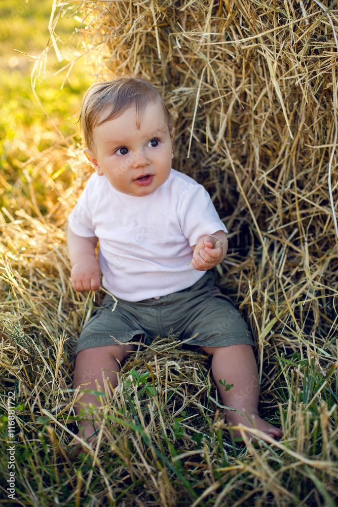 gay boy kid blonde in white tank top sitting on a field gay boy kid blonde in white tank top sitting on a field