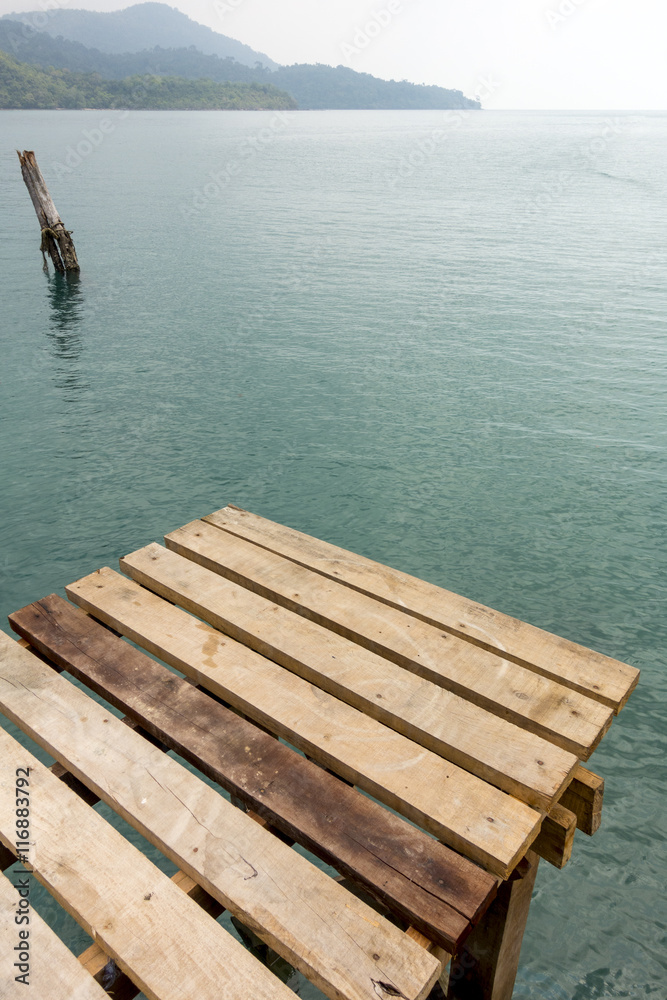 Fototapeta premium Wooden slat walkway on sky blue water background