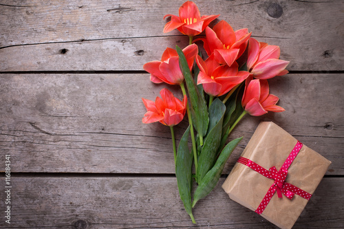 Fototapeta Naklejka Na Ścianę i Meble -  Bunch of coral tulips and wrapped box with present  on vintage
