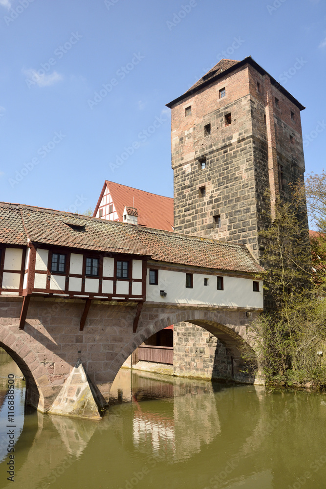 Covered Henkersteg bridge with adjacent tower in Nuremberg.