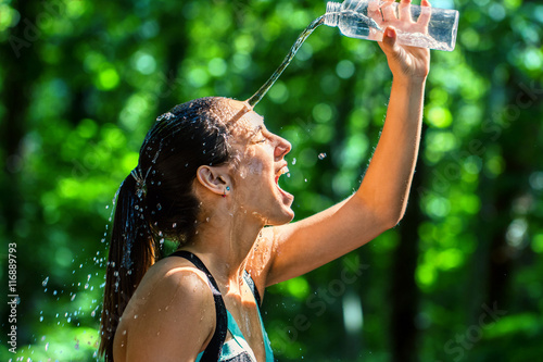 Girl pouring water on face after workout.