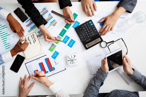 Picture of businessmen's hands on white table with documents and drafts