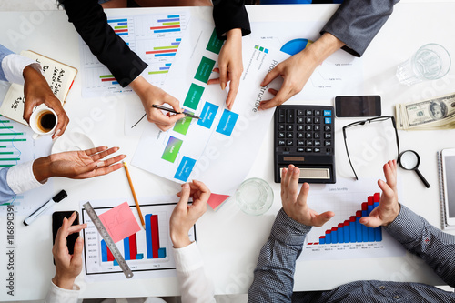 Picture of businessmen's hands on white table with documents and drafts