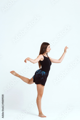 Young beautiful contemporary dancer posing over white background. Copy space.