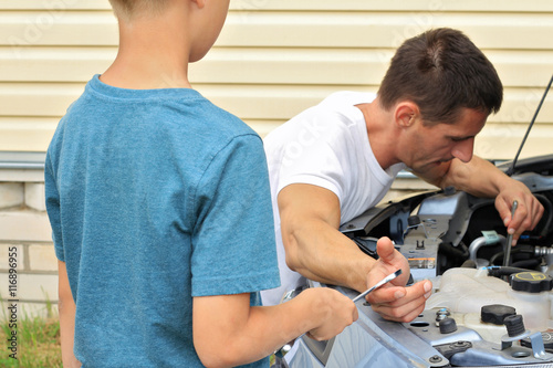 Boy helping Father to repair the car. Family concept