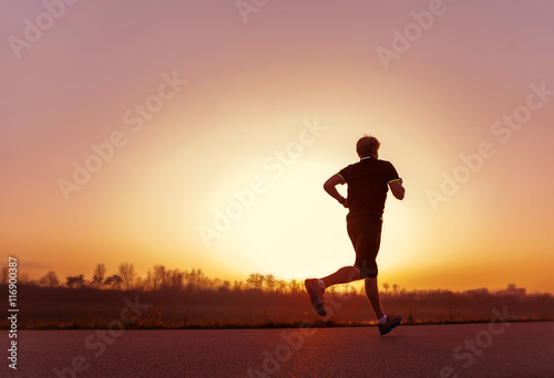 Fototapeta Naklejka Na Ścianę i Meble -  Running man silhouette in sunset time