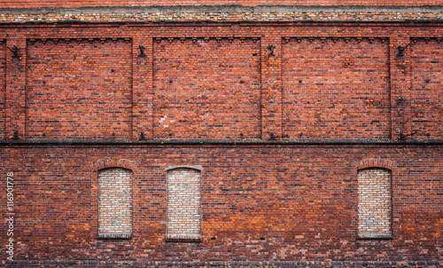wall of the old factory building of red brick with narrow window