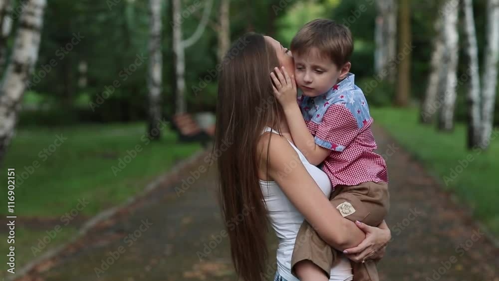 Woman Kisses and Hugs His Son in the Park