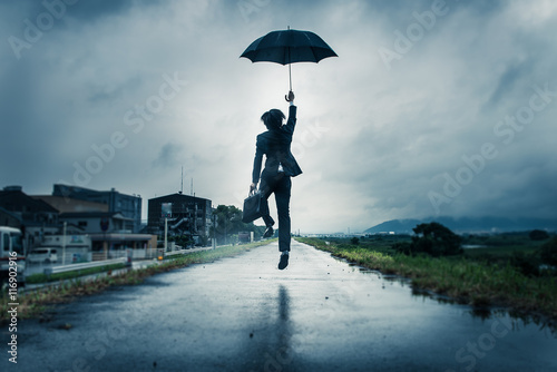 傘を差してジャンプするビジネスマン