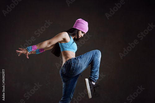 Young sexy woman dancer dancing on wall background
