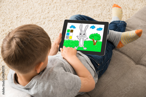 Cute Little Child Playing Game On Digital Tablet
