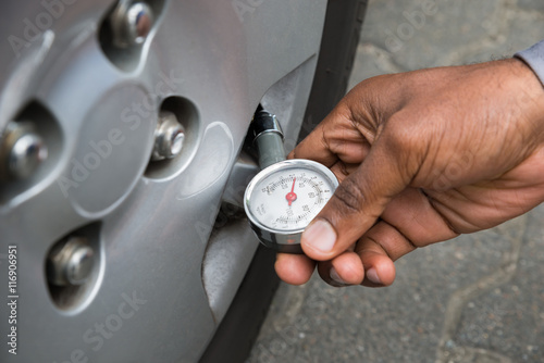 Person Holding Gauge For Measuring Tyre Pressure