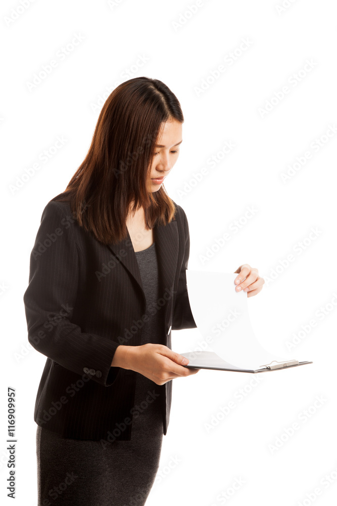 Young Asian business woman read paper on clipboard. Young Asian business woman read paper on clipboard.