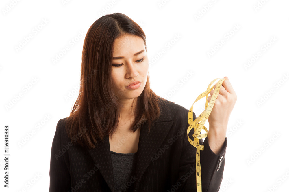 Unhappy young Asian business woman with measuring tape. Unhappy young Asian business woman with measuring tape.