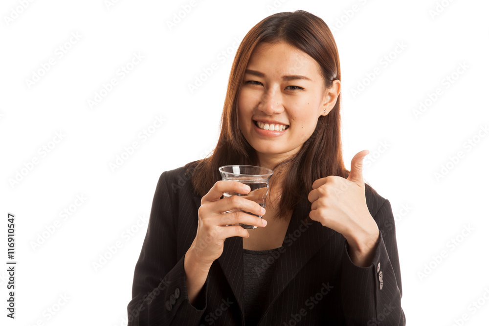 Young Asian woman thumbs up with a glass of drinking water. Young Asian woman thumbs up with a glass of drinking water.