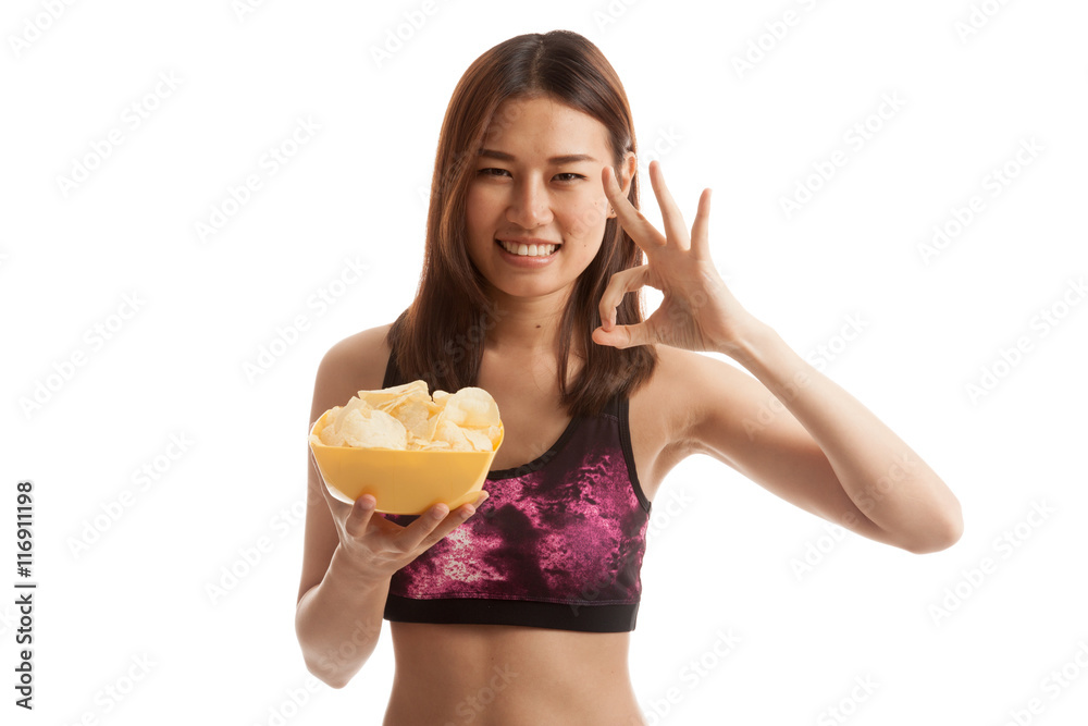 Beautiful Asian healthy girl  eat potato chips show OK sign.