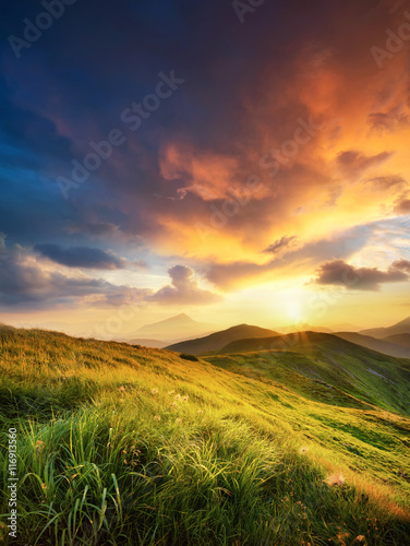 Mountain field during sunset. Beautiful natural landscape in the summer time
