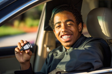 African American teenager with a new car. Graduation gift.