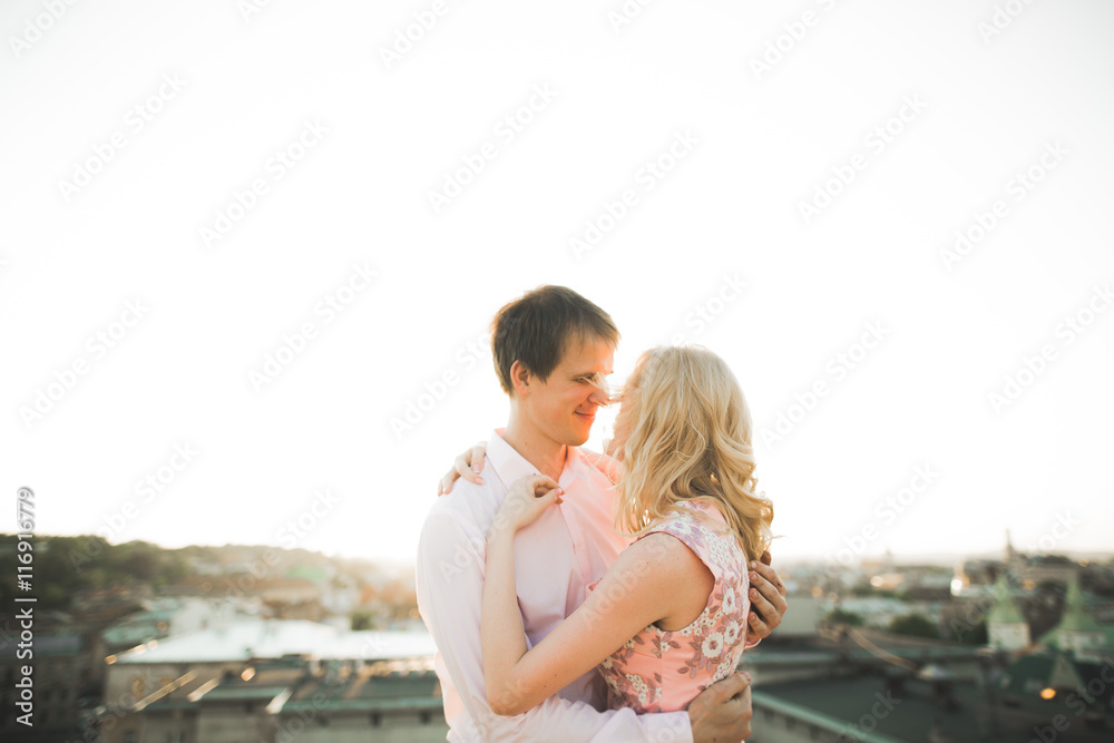 Close up portrait of happy smiling couple in love posing on roof with big balls. Landscape city Close up portrait of happy smiling couple in love posing on roof with big balls. Landscape city
