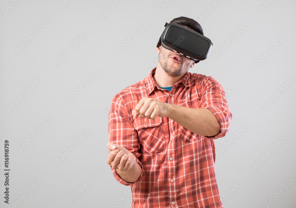 Man with virtual reality glasses paying car simulator