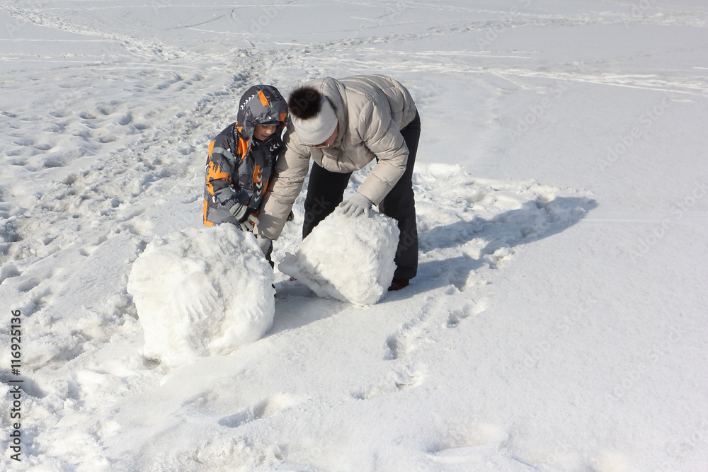 The woman in a light jacket and the little boy doing a snowball