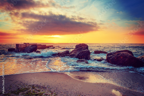 Fototapeta Naklejka Na Ścianę i Meble -  Sea coast after sunrise with rocks, blue water and sunny sky, natural seasonal summer hipster background