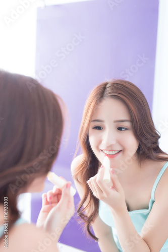 young woman painting  lip balm