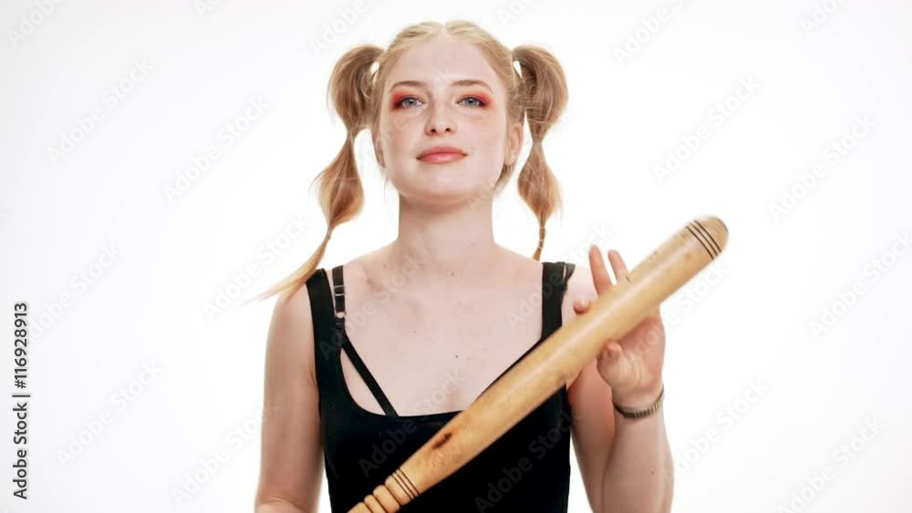 Young beautiful girl smiling, dancing with bat over white background. Slow motion. Young beautiful girl smiling, dancing with bat over white background. Slow motion.