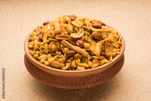 Принти на полотні Traditional indian deep fried salty dish - chivda or mixture or farsan or farsaan made of gram flour and mixed with dry fruits in teracotta bowl, artistic background