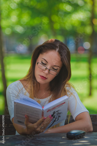 Girl with book reading at the park