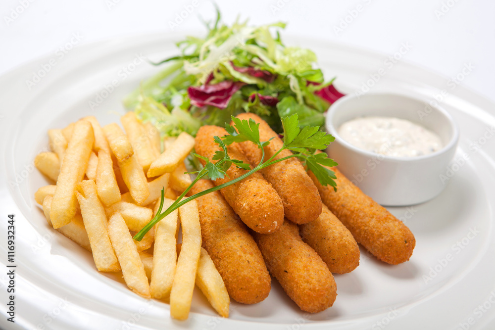 Fish sticks with sauce, fried potatoes and fresh salad lettuce on a white plate Fish sticks with sauce, fried potatoes and fresh salad lettuce on a white plate