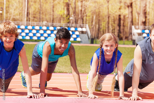 Happy teens doing push-up exercises on the track