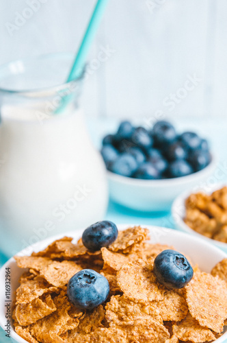 healthy breakfast, cornflakes blueberry and milk, nuts, almond with text space top view close-up instagram filter