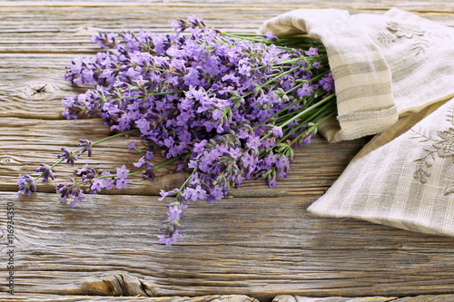 Fototapeta Naklejka Na Ścianę i Meble -  Bouquet of lavender with linen aroma sack on wooden table 