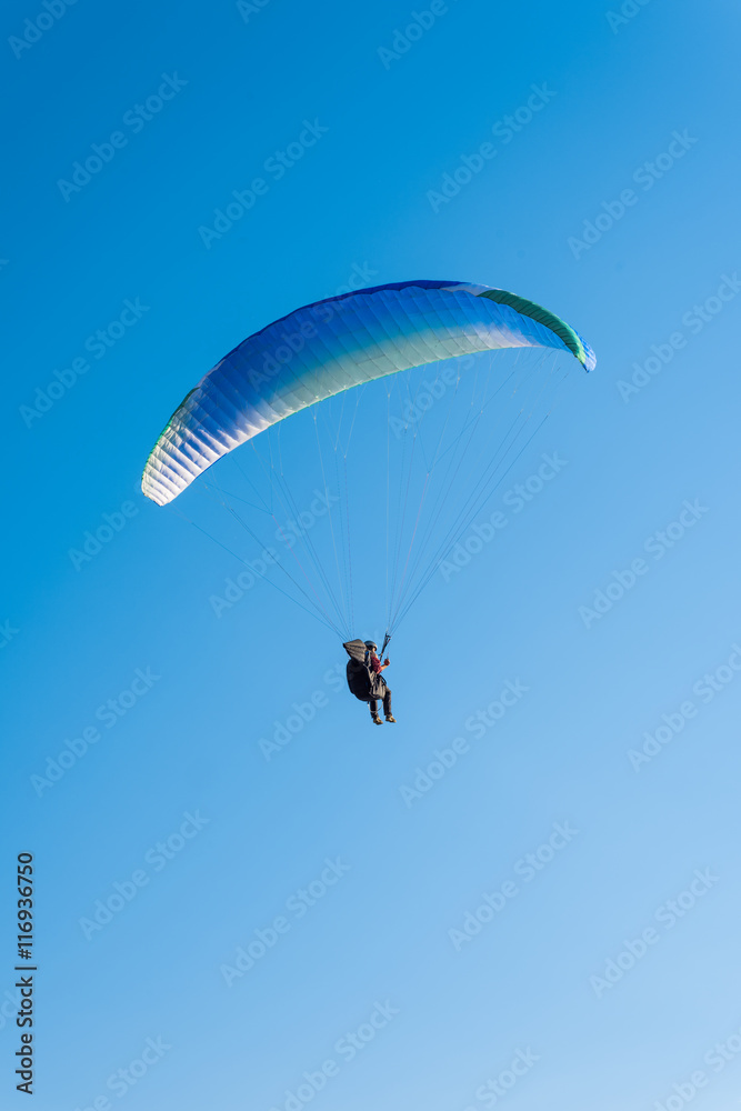 Paragliding in the sky. Man flying a paraglider on the sun. Paragliding in the sky. Man flying a paraglider on the sun.