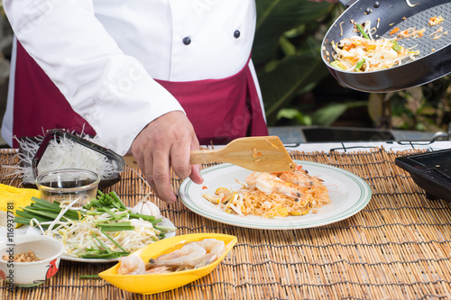 Chef putting Pad Thai to the plate photo