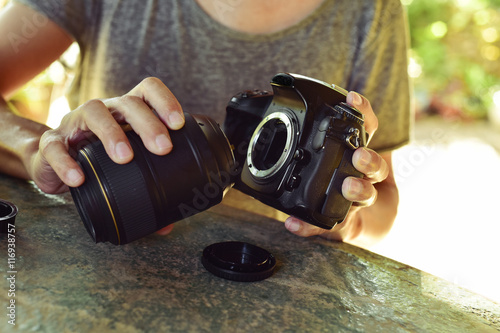 Foto man taking out the lens of his camera
