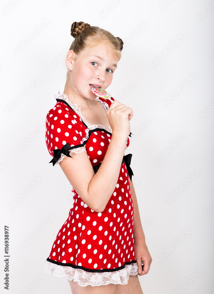 Portrait of happy beautiful young girl with sweet candys. pretty young woman dressed in a red dress with white polka dots holding two colorful lollipop Portrait of happy beautiful young girl with sweet candys. pretty young woman dressed in a red dress with white polka dots holding two colorful lollipop