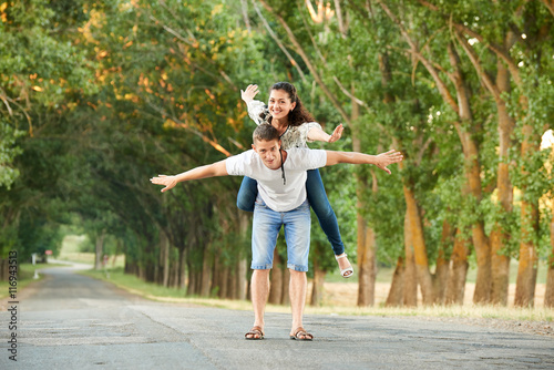 young couple walk on country road with high trees, romantic people concept, summer season