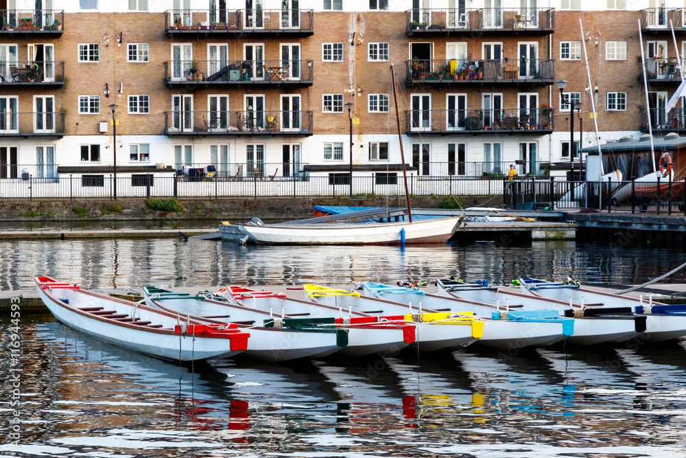 Row of boats decorated with different colours, moored in Millwall Outer Dock in London